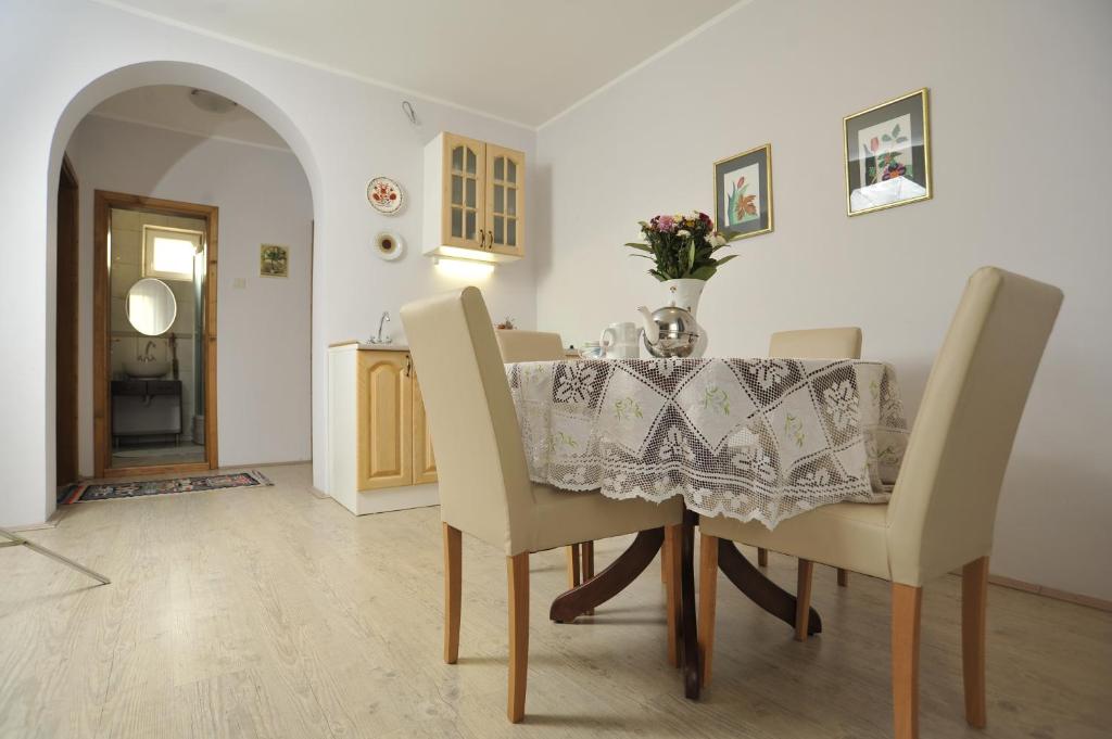 a dining room with a table with a vase on it at Apartments Izvor in Vrdnik