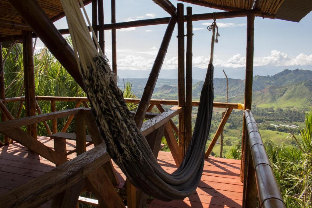 a hammock on a deck with mountains in the background at Hotel Spa La Colina in Pereira