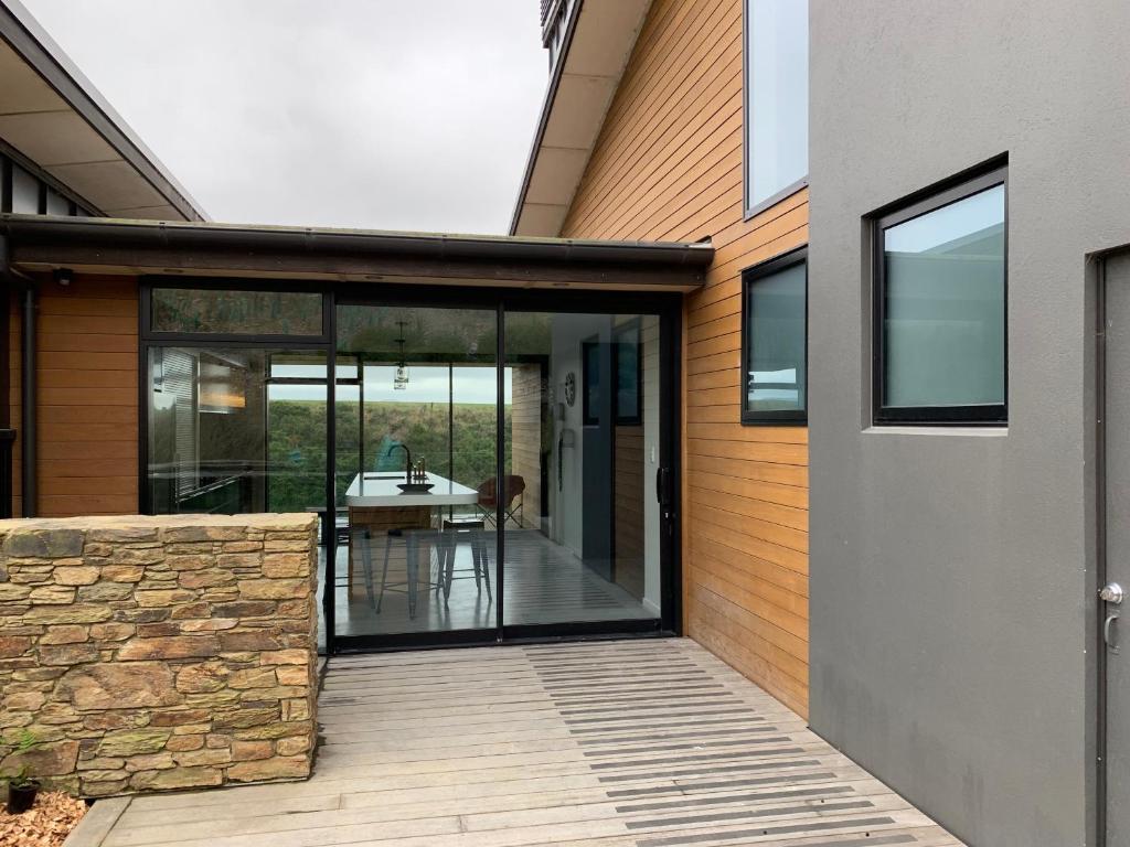 a pivot door of a house with a patio at Secluded Getaway in Oamaru
