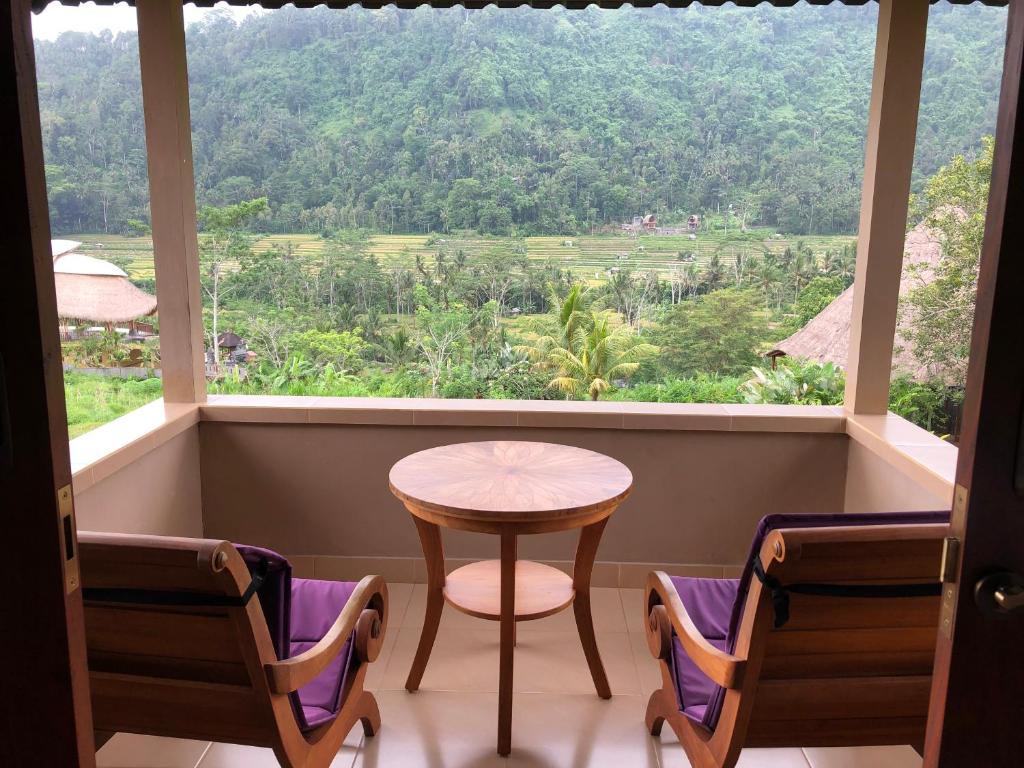 stół i krzesła w pokoju z dużym oknem w obiekcie Nirarta Center For Living Awareness w mieście Sidemen