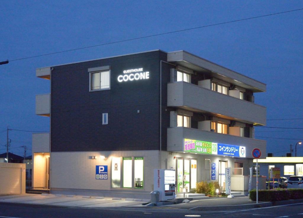 ゲストハウス岐阜羽島心音 Guest House Gifuhashima COCONE في Hashima: مبنى أسود مع علامة على جريمة الإنترنت