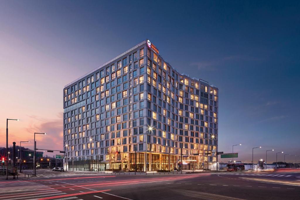 a tall glass building with a lot of windows at Ramada Encore by Wyndham Gimpo Han River Hotel in Gimpo