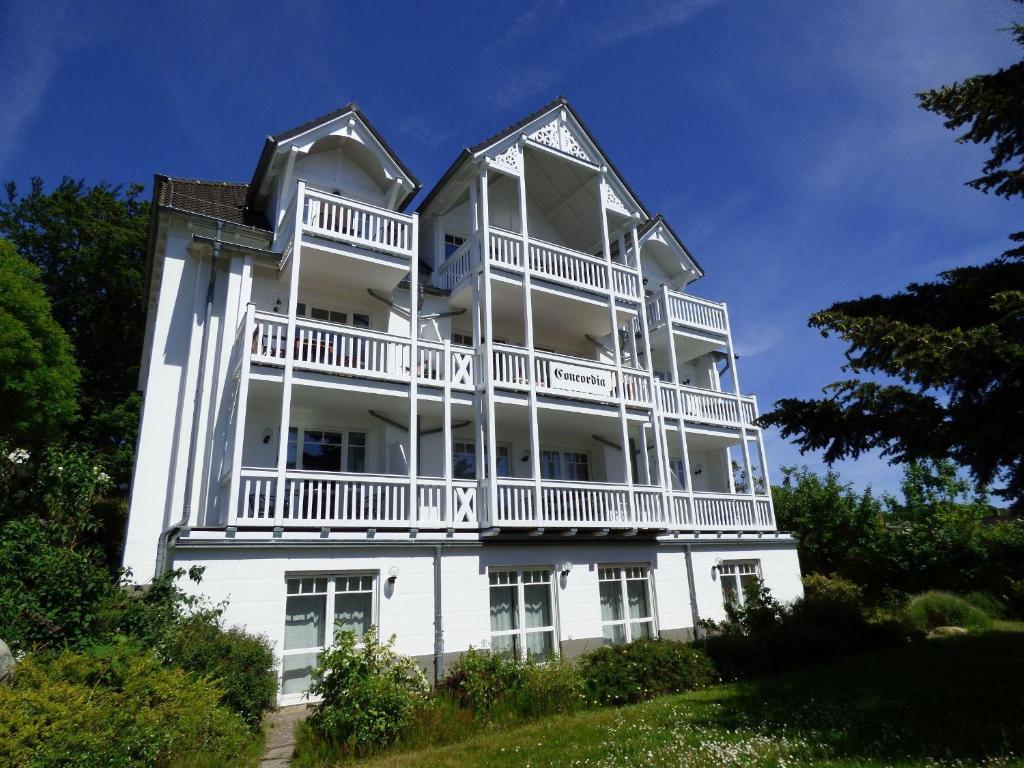 ein großes weißes Gebäude mit Balkon darüber in der Unterkunft Ferienwohnung "Parkresidenz Concordia" - Wohnung 9 in Ostseebad Sellin