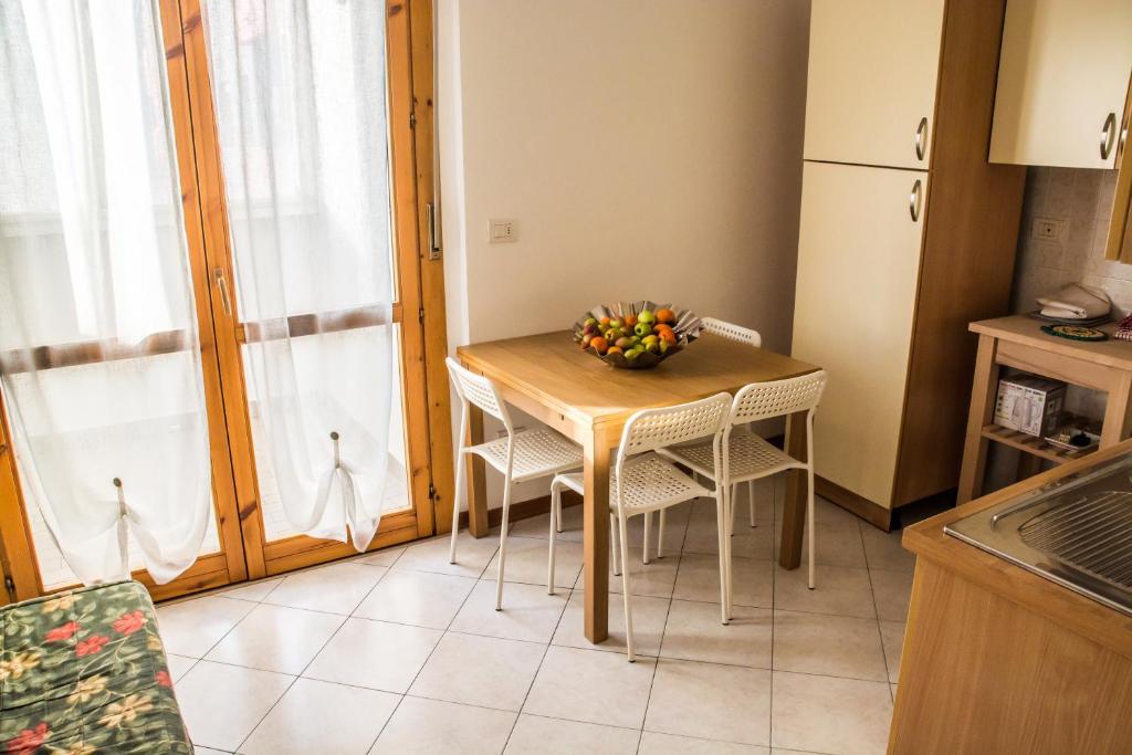 a kitchen with a table with chairs and a bowl of fruit on it at New A Casa da Ida in Parma