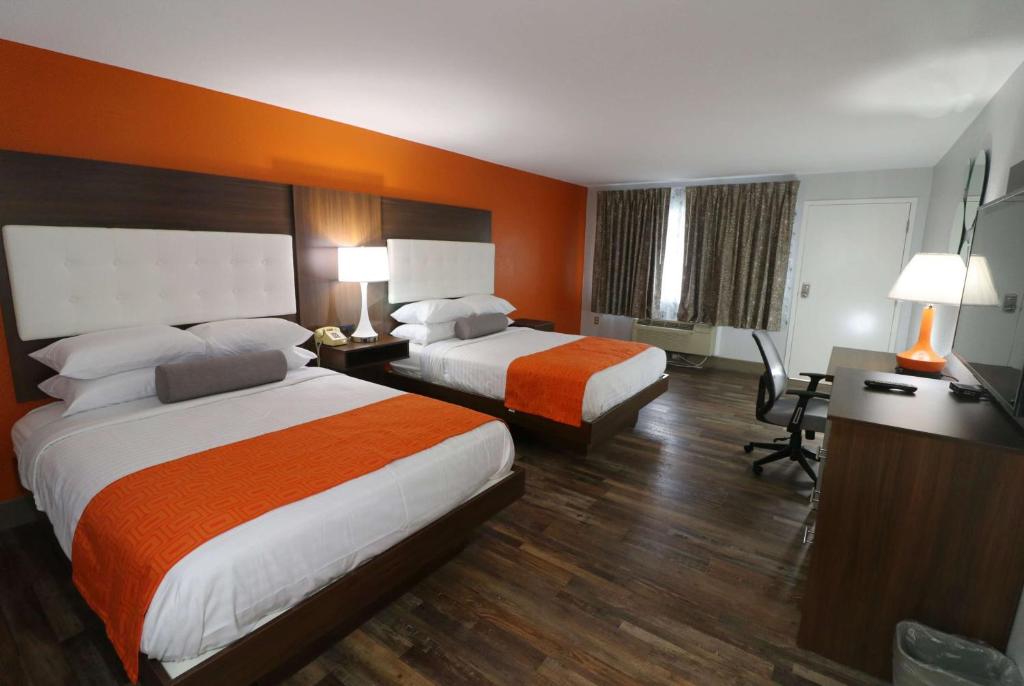 a hotel room with two beds and a desk at Howard Johnson by Wyndham Downtown Gatlinburg in Gatlinburg