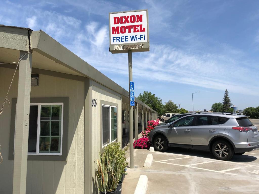 una señal para un motel de diversión con un coche aparcado fuera en Dixon Motel, en Dixon