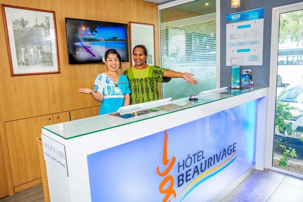 a man and a woman standing behind a counter at Hotel Beaurivage in Noumea