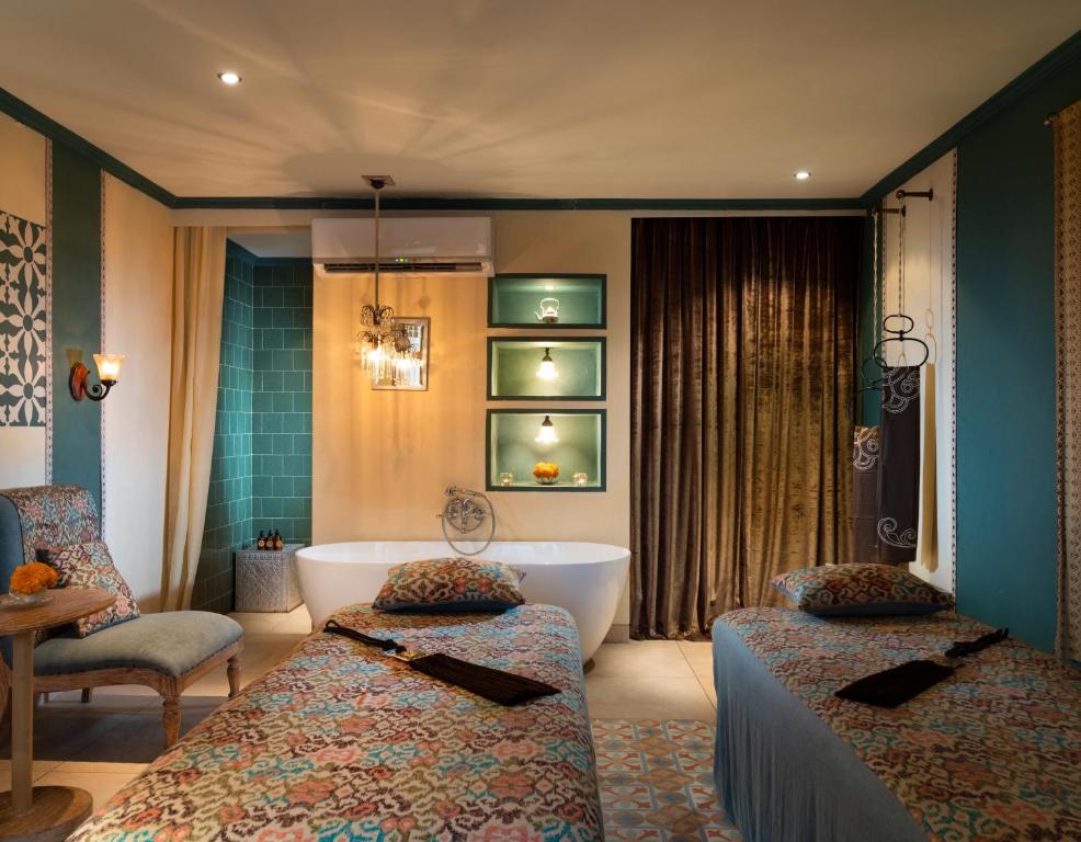 a hotel room with two beds and a bath tub at Amnaya Resort Kuta in Kuta
