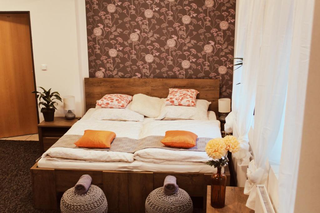 a bedroom with a bed with orange pillows on it at Apartmány Caffe & Grill in Roudnice nad Labem
