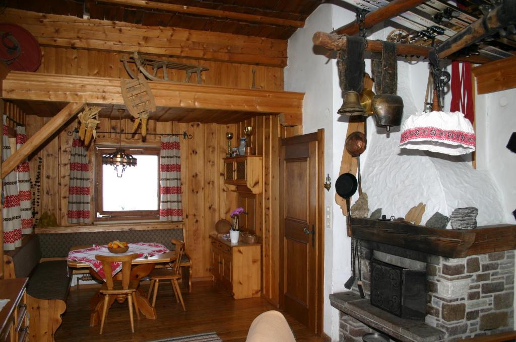 a kitchen and dining room with a fireplace in a cabin at Ferienhaus Soregina in Ellmau