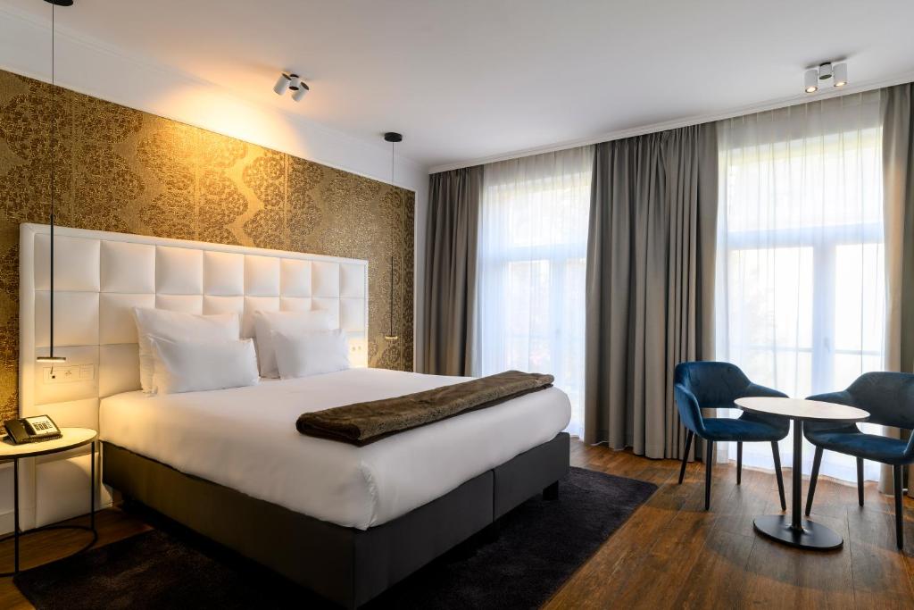 une chambre d'hôtel avec un lit, une table et des chaises dans l'établissement Hotel Rubens-Grote Markt, à Anvers