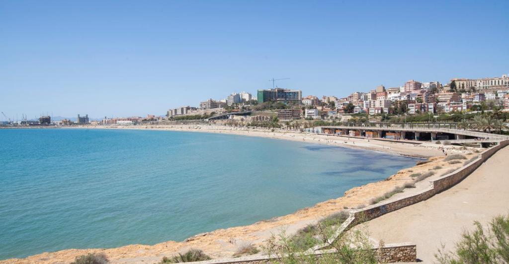 a view of a beach with buildings in the background at Villa hortencia in Tarragona