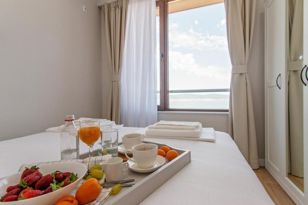 a table with a tray of fruit and a glass of wine at Mary Homes in Nesebar