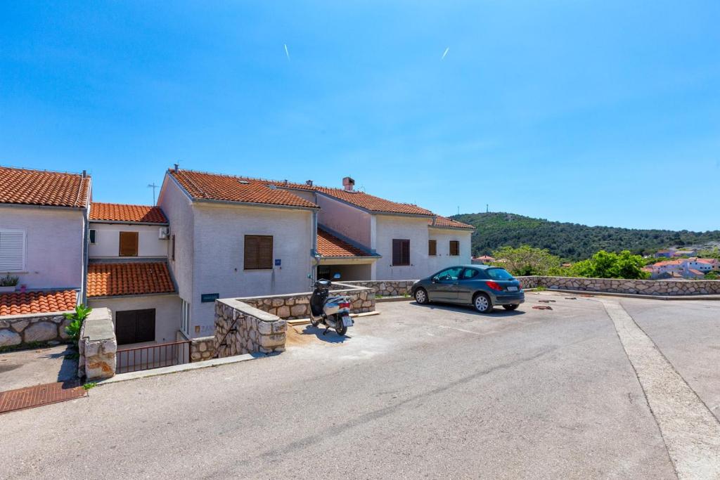 une voiture garée dans un parking à côté d'un bâtiment dans l'établissement Apartments Gisela, Mali Lošinj, à Mali Lošinj