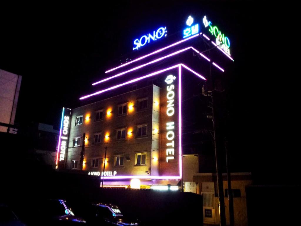 un edificio con letreros de neón por la noche en Sono Hotel, en Gyeongju