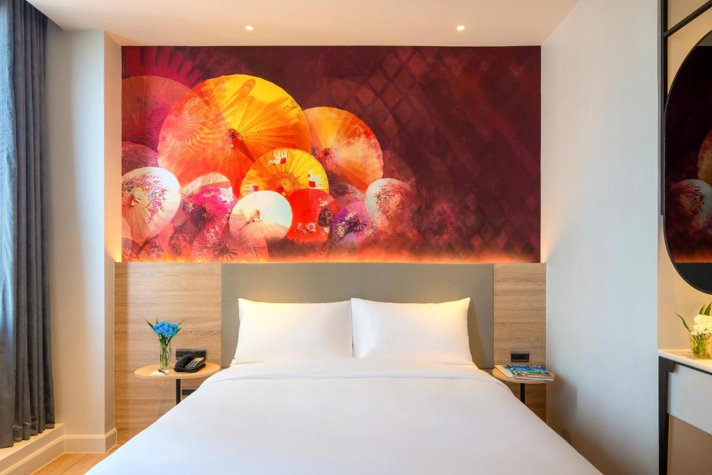 A double room focused on its bed, with umbrella artwork and bedside tables.
