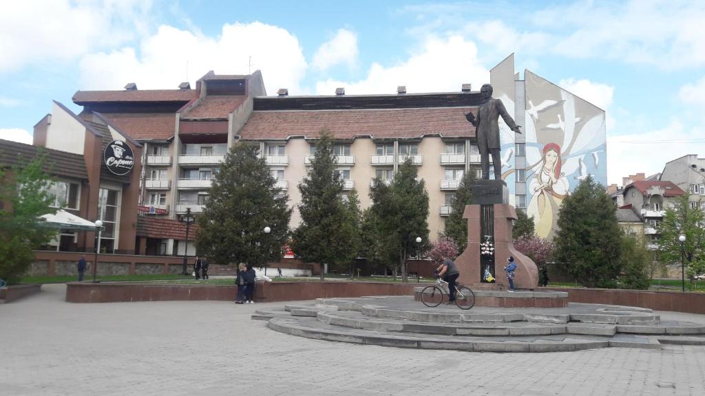 a statue in a plaza in front of a building at КП ДР Готель in Drohobytsch