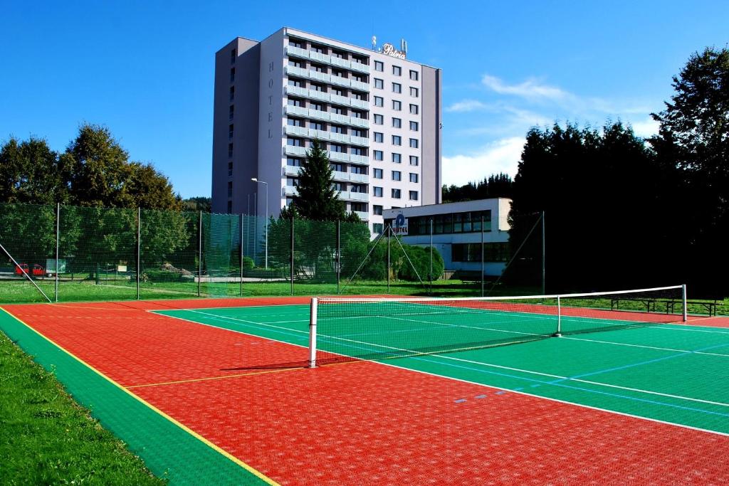 a tennis court with a building in the background at PATRIA HOTEL in Trutnov