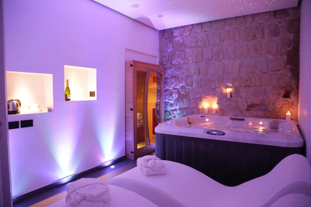 a bathroom with a tub and a stone wall at Cellamare Suite & Spa in Naples