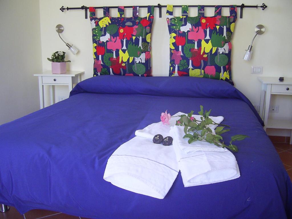 Casa Falcone B&B في سكالا: سرير ازرق وعليه مناشف وزهور