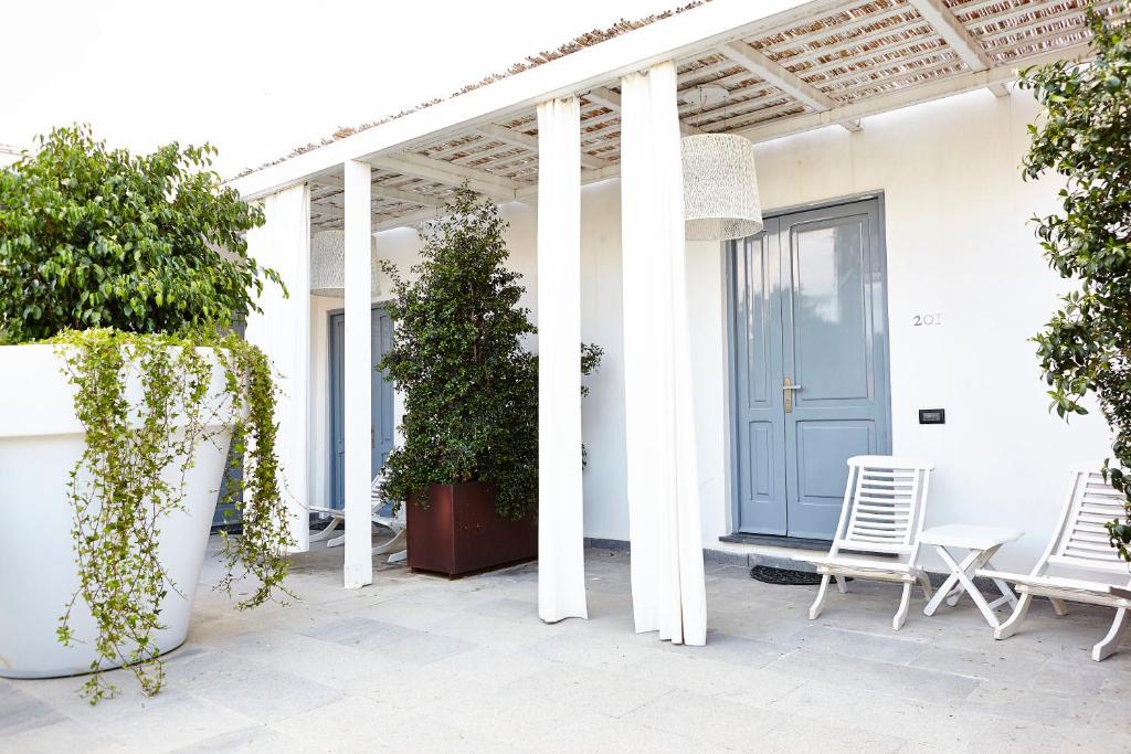 a white house with white columns and a blue door at La Suite Boutique Hotel in Procida