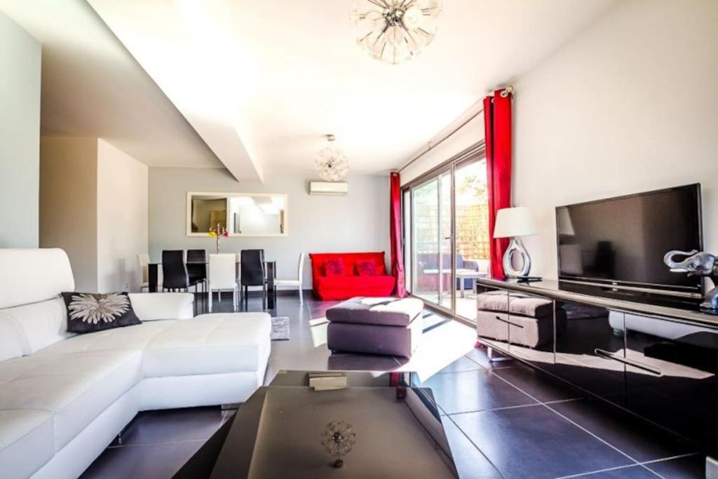 un salon avec un canapé blanc et une télévision dans l'établissement APPARTEMENT TERRASSE CITA DI SALI PORTO VECCHIO, à Porto-Vecchio