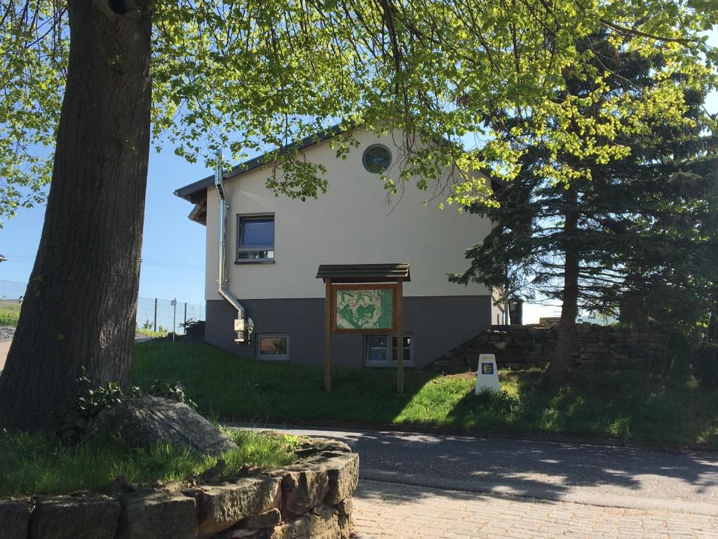 una casa blanca con un cartel delante en Ferienhaus: "Casa de Summer" en Birkenfelde