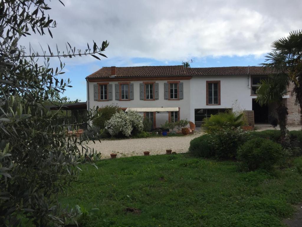 una casa blanca con un patio delante en Domaine en castanet, en Caraman