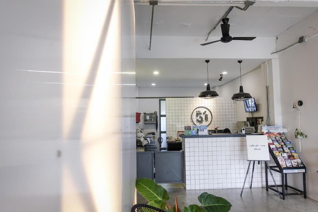 A compact reception area with a tiled counter, hanging lights, and local information displays.