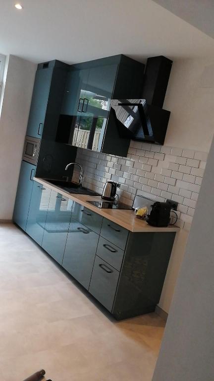 a kitchen with black cabinets and a counter top at les Pénates appartement terrasse in Saint-Max