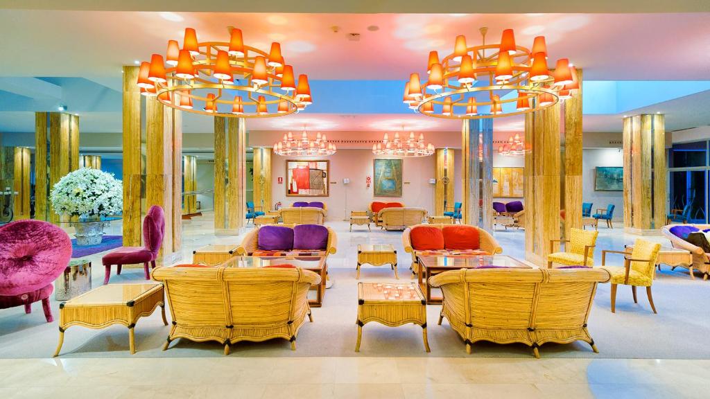 a restaurant with colorful chairs and tables and chandeliers at Bull Reina Isabel & SPA in Las Palmas de Gran Canaria