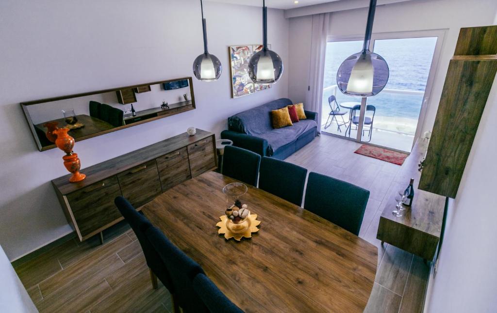 salon z drewnianym stołem i kanapą w obiekcie Seafront Apartment No 10 Marsalforn w mieście Marsalforn