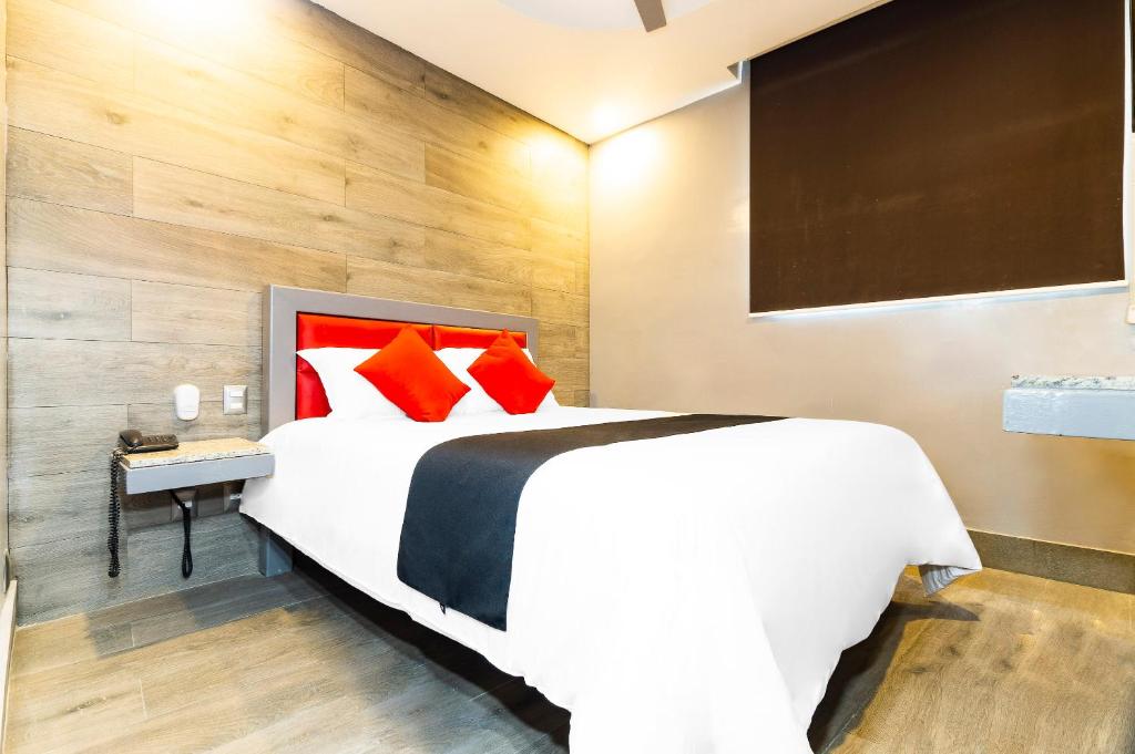 1 dormitorio con 1 cama blanca grande con almohadas rojas en Hotel Sonora, en Ciudad de México