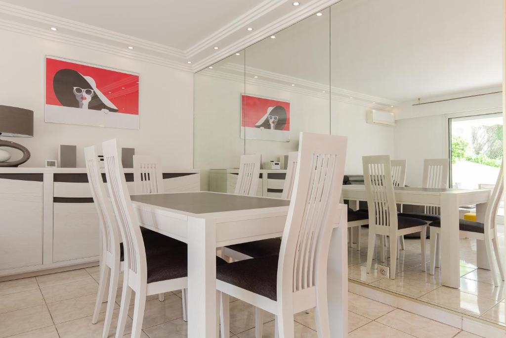 une salle à manger blanche avec une table et des chaises blanches dans l'établissement Villa AD’ALTA, à Cannes