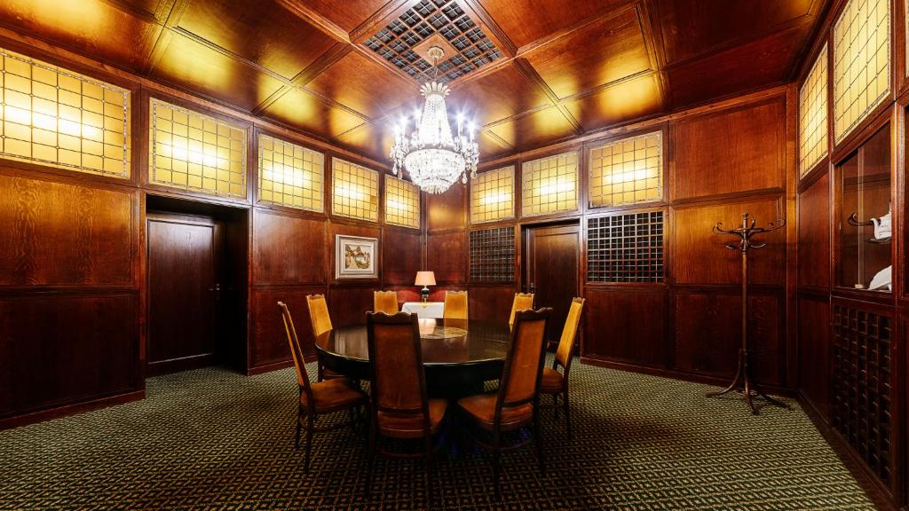 a dining room with a table and chairs and a chandelier at Grandhotel Brno in Brno