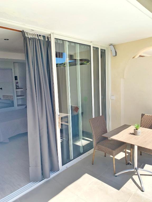 a room with a table and chairs and a window at Hôtel Beau Soleil in Le Lavandou
