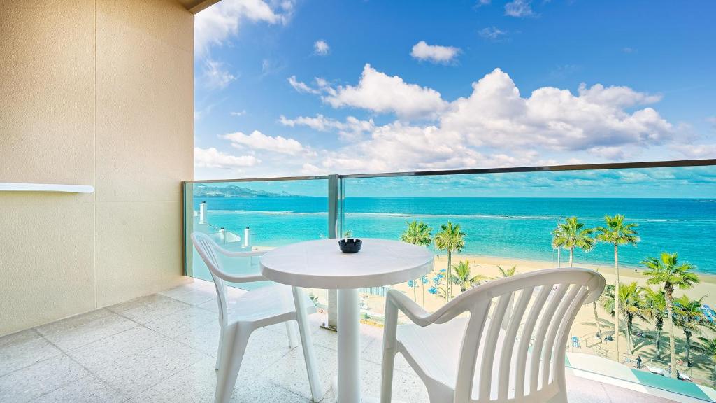 a white table and chairs in a room with a view of the ocean at Bull Reina Isabel & SPA in Las Palmas de Gran Canaria