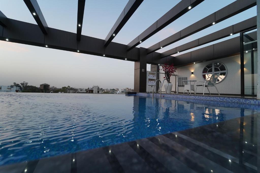 a swimming pool with a clock on the side of a building at Rockland Hotel, C.R Park in New Delhi