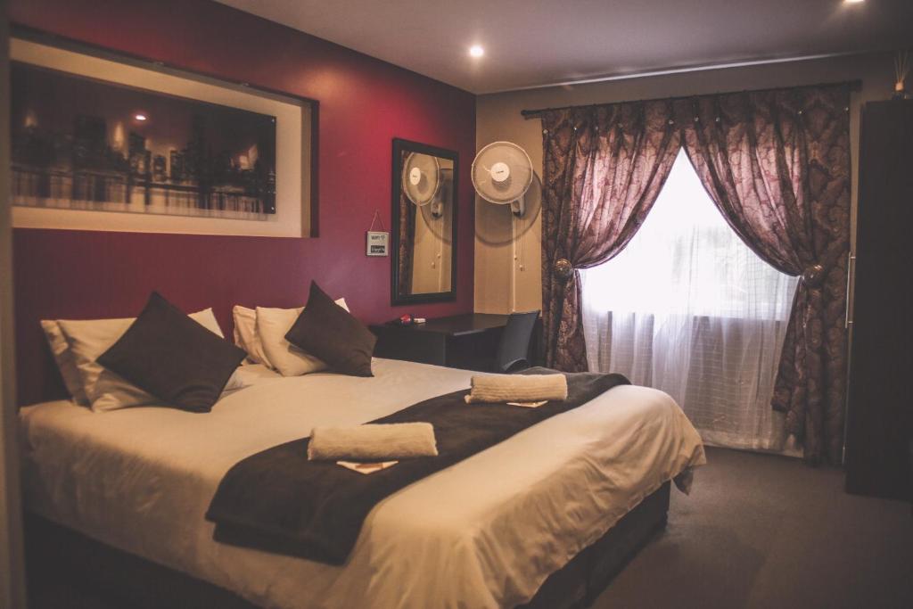 een slaapkamer met een groot bed en een raam bij Biggy Best Boutique Hotel & Self Catering Cottages in Howick