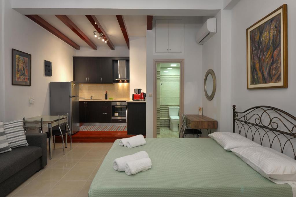 a living room and kitchen with a bed and a couch at Milonas Studios in Corfu