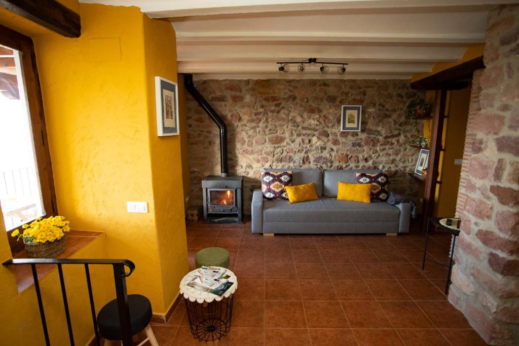 a living room with a couch and a wood stove at El Portal de Vilafamés in Vilafamés