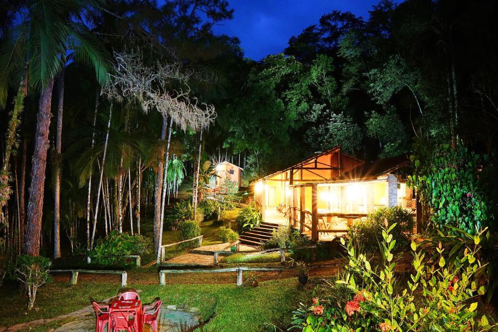 a house in the middle of a forest at night at Pousada Arapassu in Eldorado