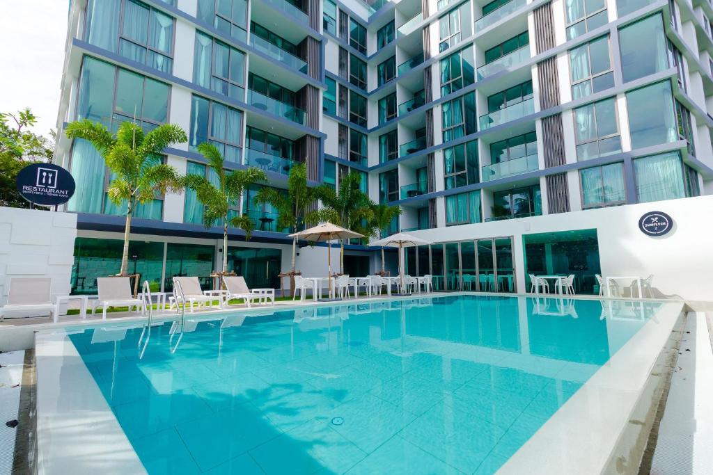 a swimming pool in front of a building at Oceanstone by Holy Cow, 2-BR, 60 m2, tree view in Bang Tao Beach