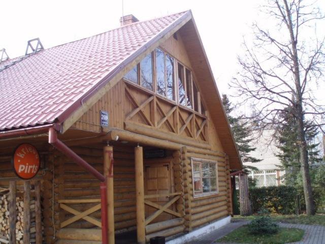 a large wooden cabin with a large roof at Izbushka in Riga