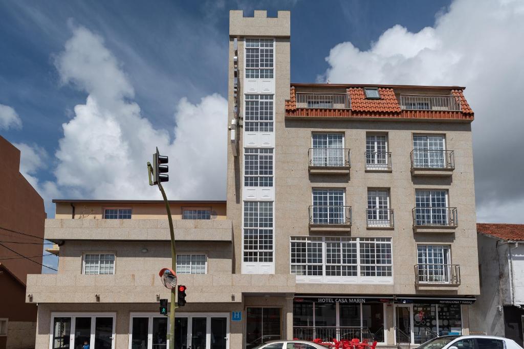 un edificio alto con ventanas en una calle de la ciudad en Hotel Casa Marín, en A Revolta