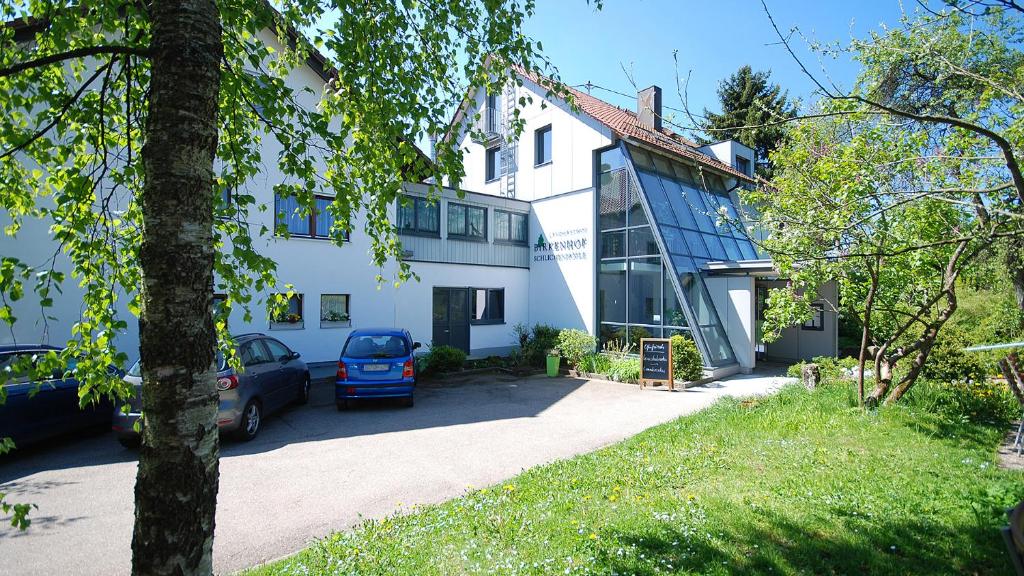 un edificio bianco con un'auto parcheggiata di fronte di Gasthof Birkenhof a Althütte