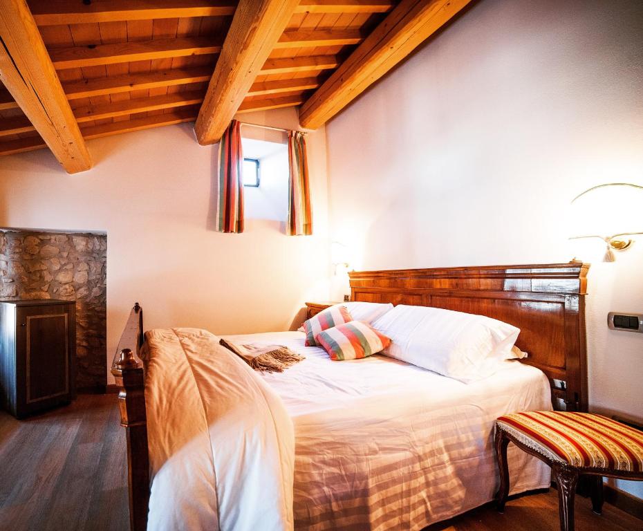 ソアーヴェにあるLocanda Lo Scudoのベッドルーム1室(木製ヘッドボード付きのベッド1台付)
