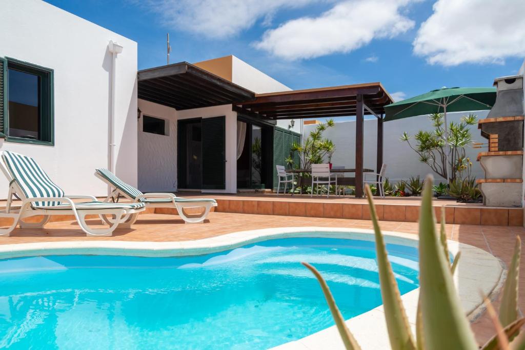 a villa with a swimming pool and a house at Ciel y Mar in La Oliva