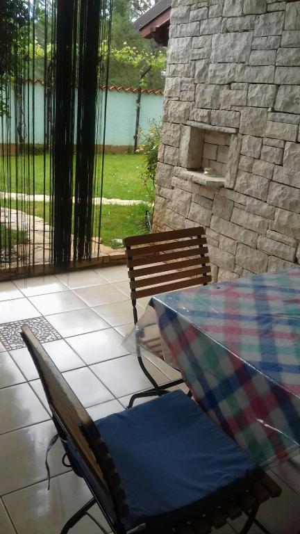 a patio with a table and a chair and a bench at Villa Verde Apartments and Rooms in Premantura