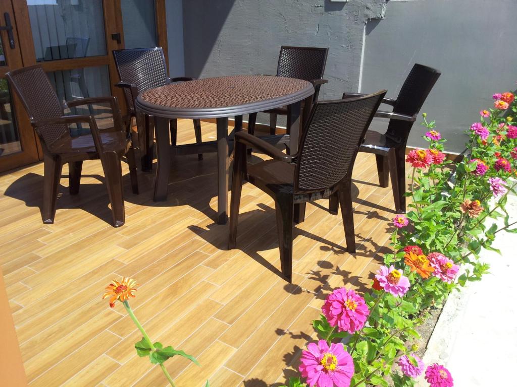una mesa y sillas en un patio con flores en Hotel GAIA, en Sozopol